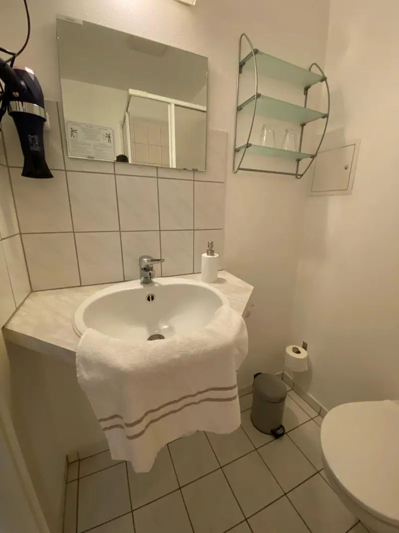 Waschbecken mit Spiegel und Handtüchern im Bad