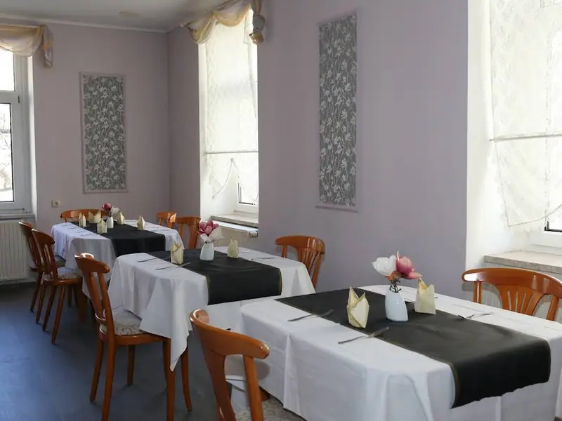 Frühstücksraum im Hotel Rathaus Eibenstock mit eingedeckten Tischen