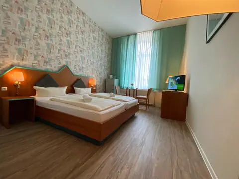 Doppelzimmer im Hotel Rathaus Eibenstock mit Doppelbett und großem Fenster