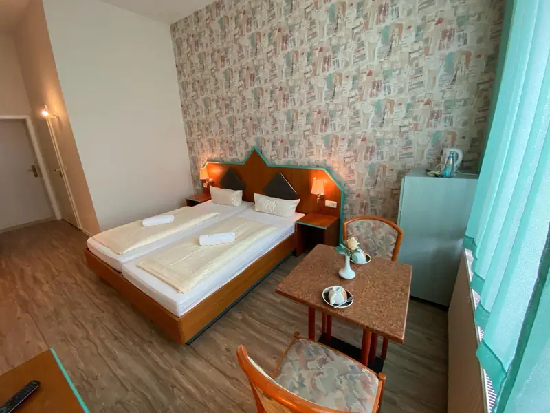 Doppelzimmer mit Tisch und zwei Sesseln