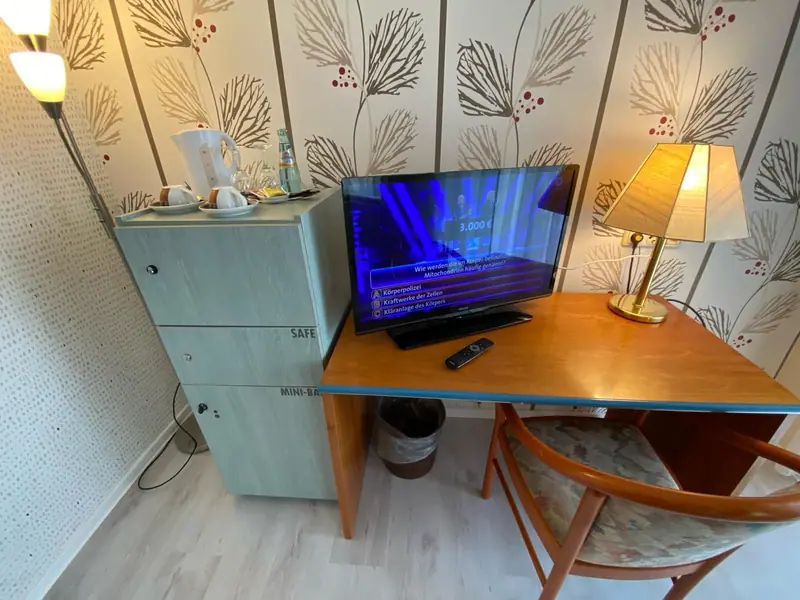 Schreibtisch mit Fernseher und Leselampe im Zimmer